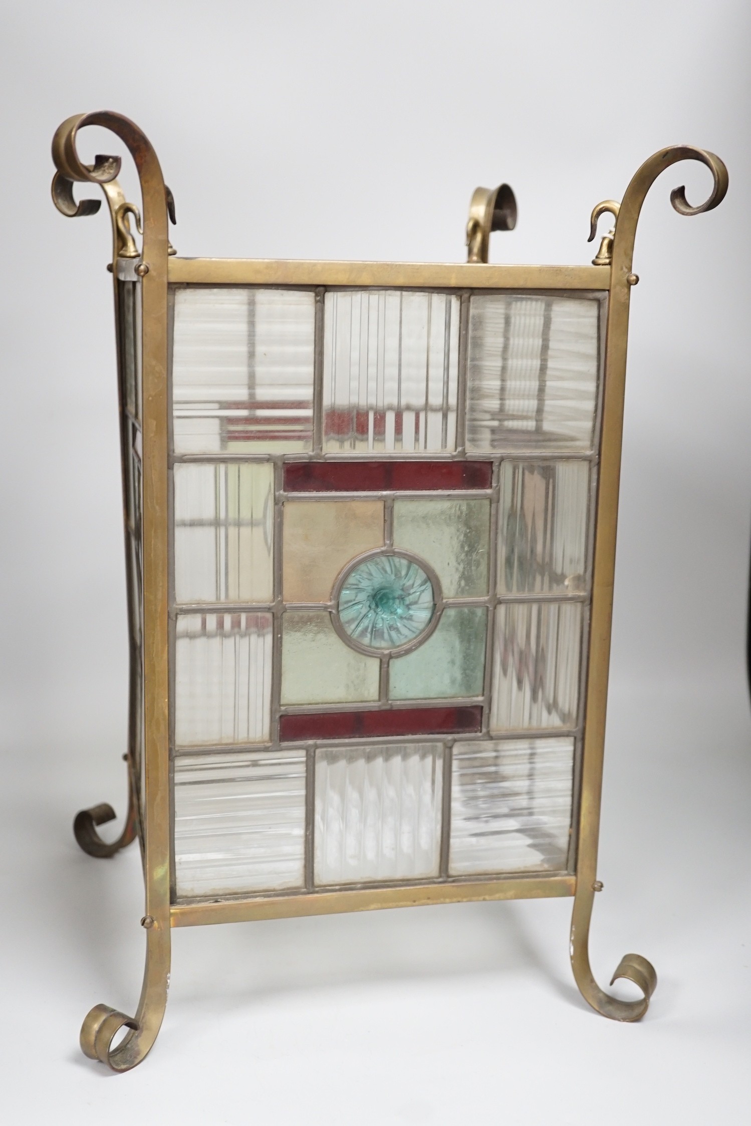 An Arts and Crafts brass and stained glass porch lantern. 46cm tall